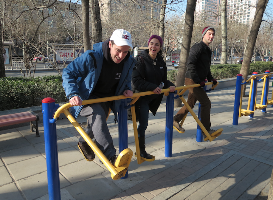Some of the other students on exercising equipment at the park